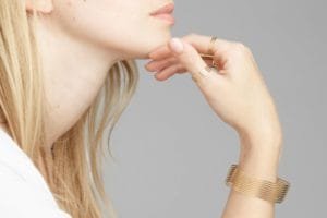 Close-up of a woman wearing Mayre’s minimalist gold rings and bracelet, showcasing the brand’s signature thin steel design.