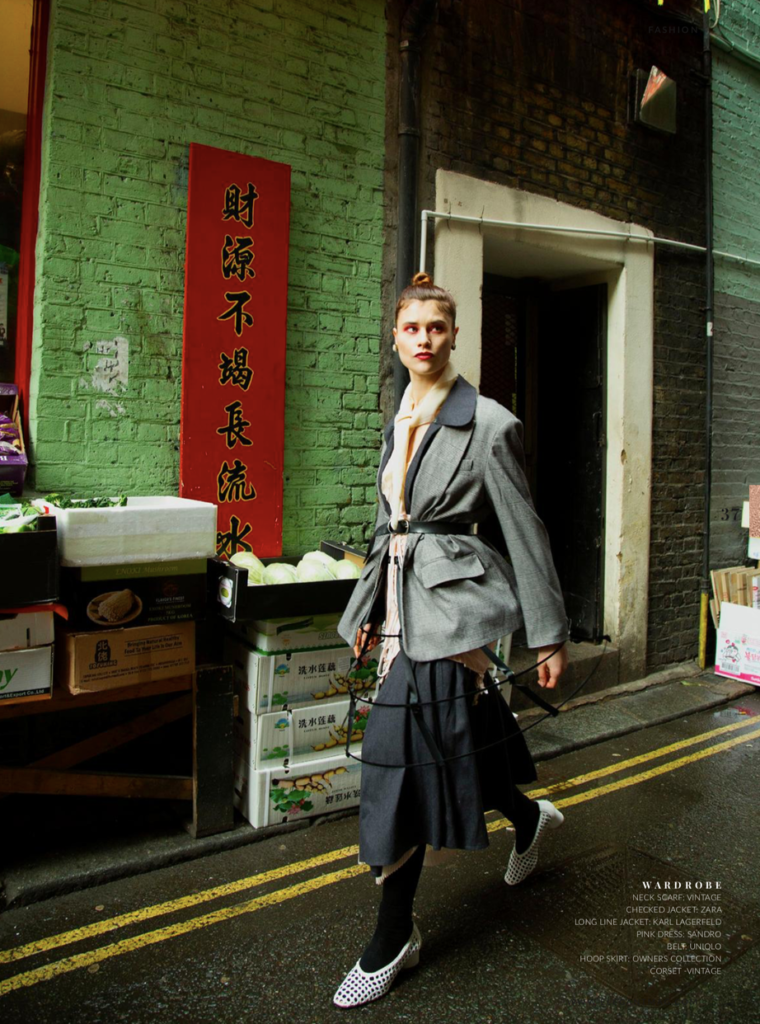 Model posing in a chic outfit on a bustling London street, captured by a fashion photographer.