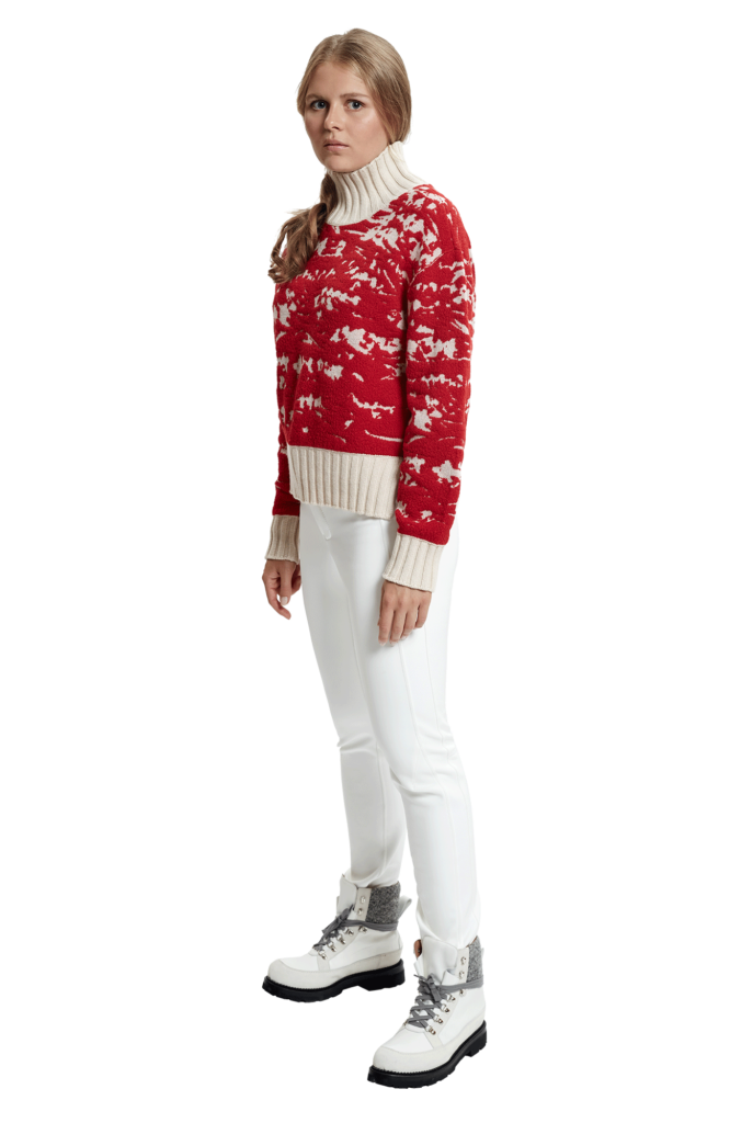 A alsy in a red and cream ski sweater as a skiwear